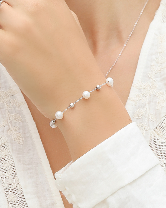 Pearl bracelet on a model wearing a white outfit