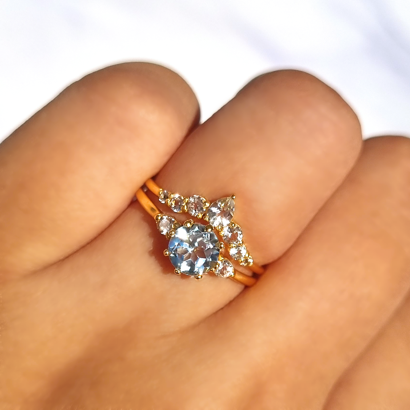 Round cut sky blue topaz and white topaz three stone engagement and wedding ring stack in 18K gold vermeil