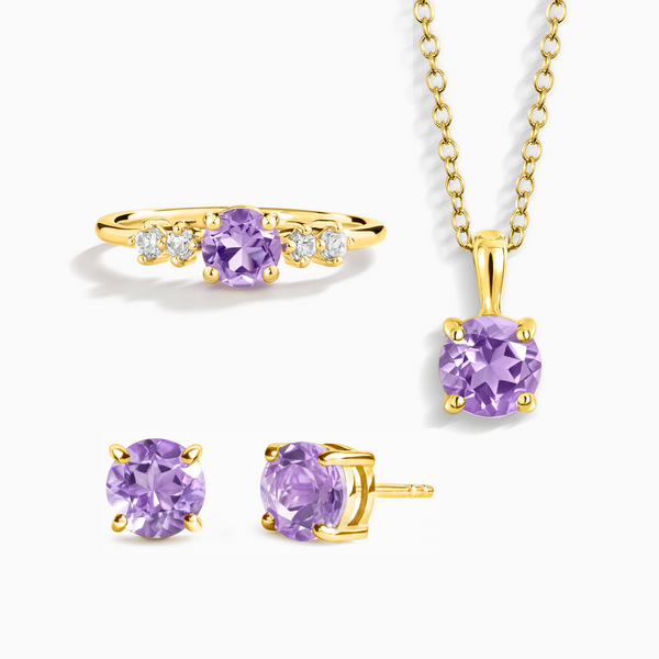 Gold jewelry set with purple gemstones on a white background