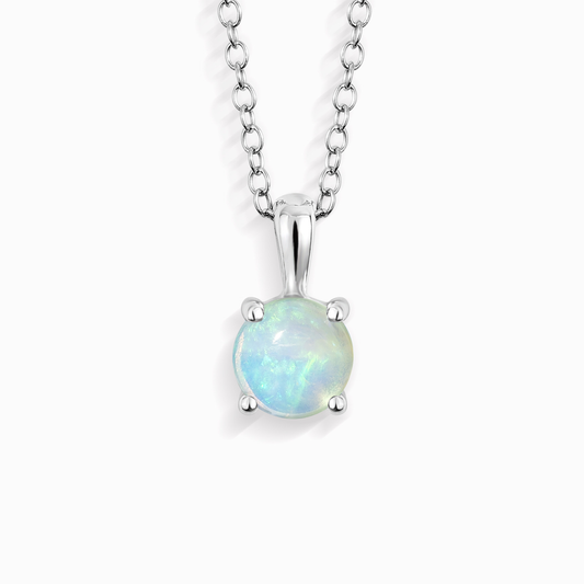 A silver pendant necklace featuring a round, prong-set iridescent opal gemstone on a delicate silver cable chain, shown against a plain white background.
