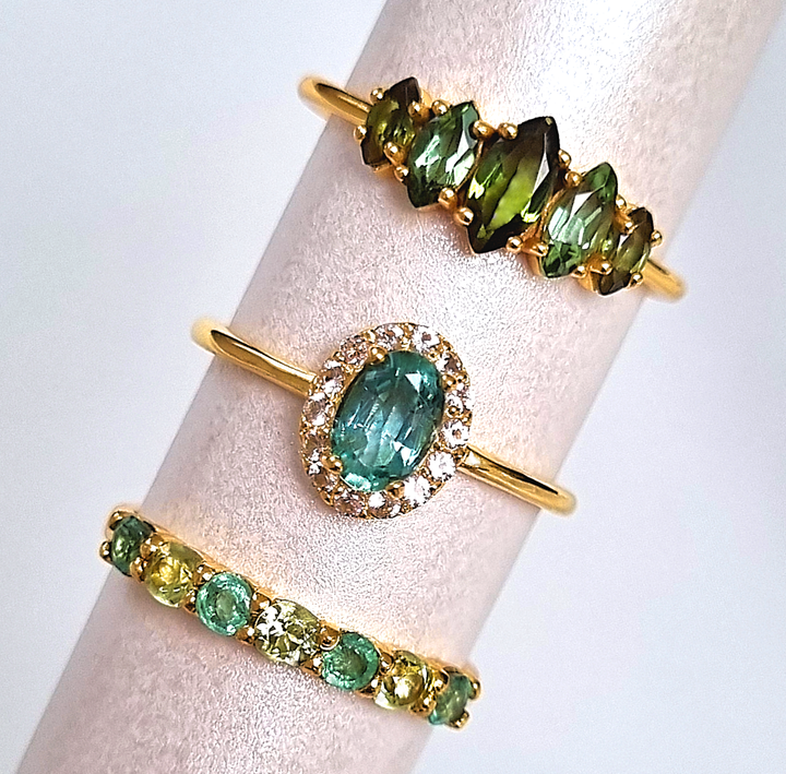 A group of green gemstone rings including emerald , peridot and Ombre Tourmaline engagement and wedding ring set in 18k gold vermeil.